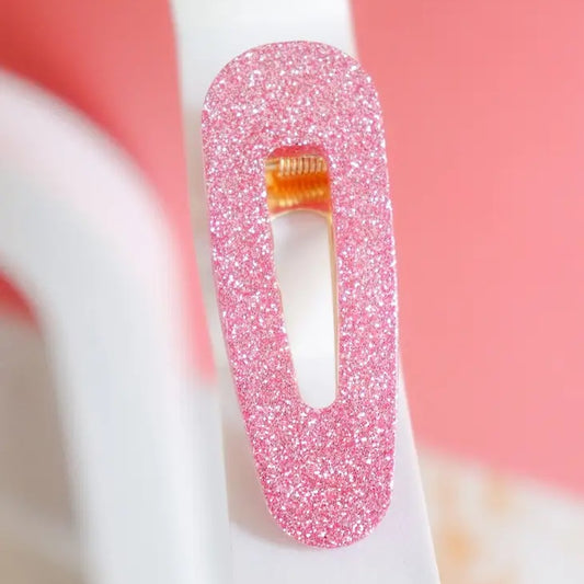 Vaaleanpunainen glitterhiuspinni.