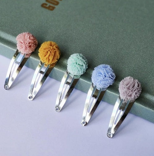 Hiusklipsisetti Pom Pom viisi eriväristä hiusklipsiä.